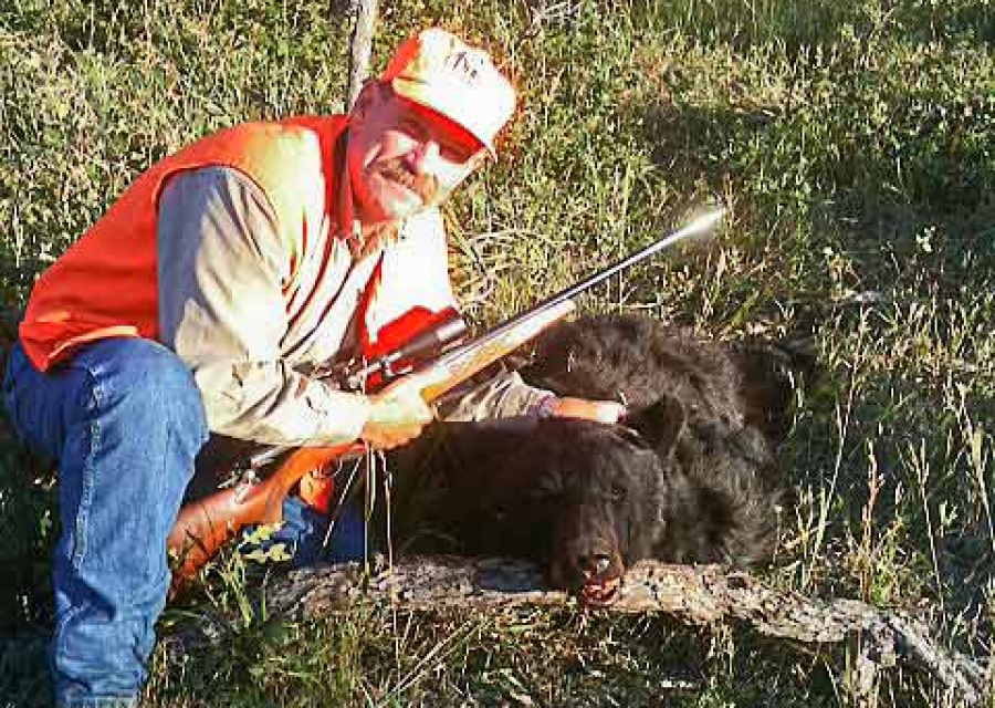 Happy hunter with a black bear harvested on the ranch.