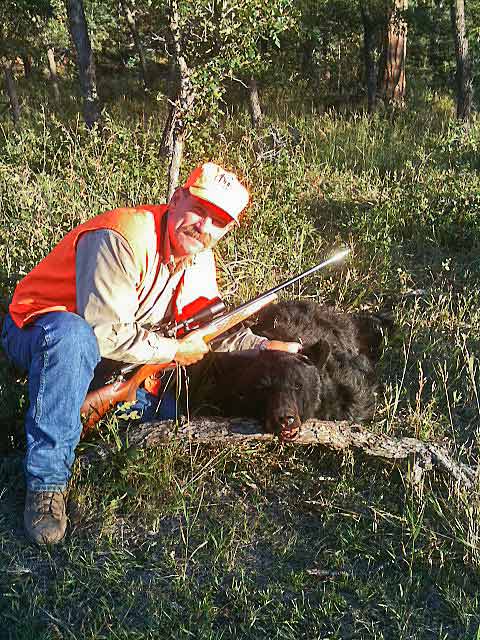 Happy hunter with a black bear harvested on the ranch.